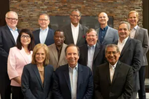 A group of men and women in business attire smiling at the camera