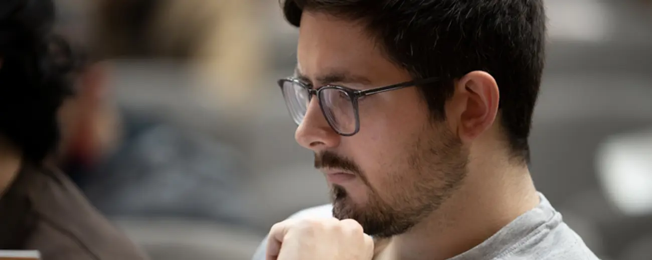 A man with brown hair and glasses